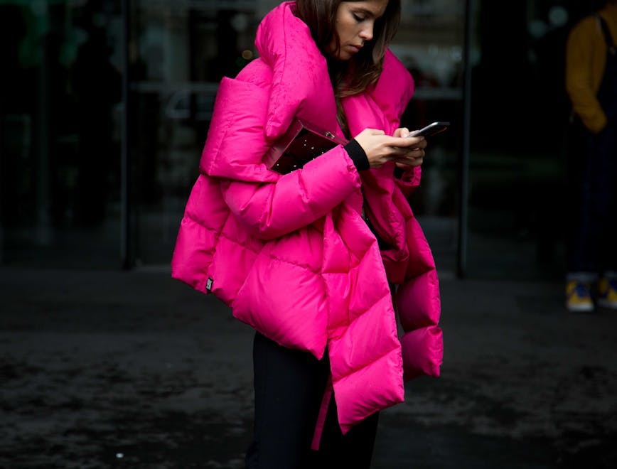 clothing apparel person human coat jacket overcoat phone electronics